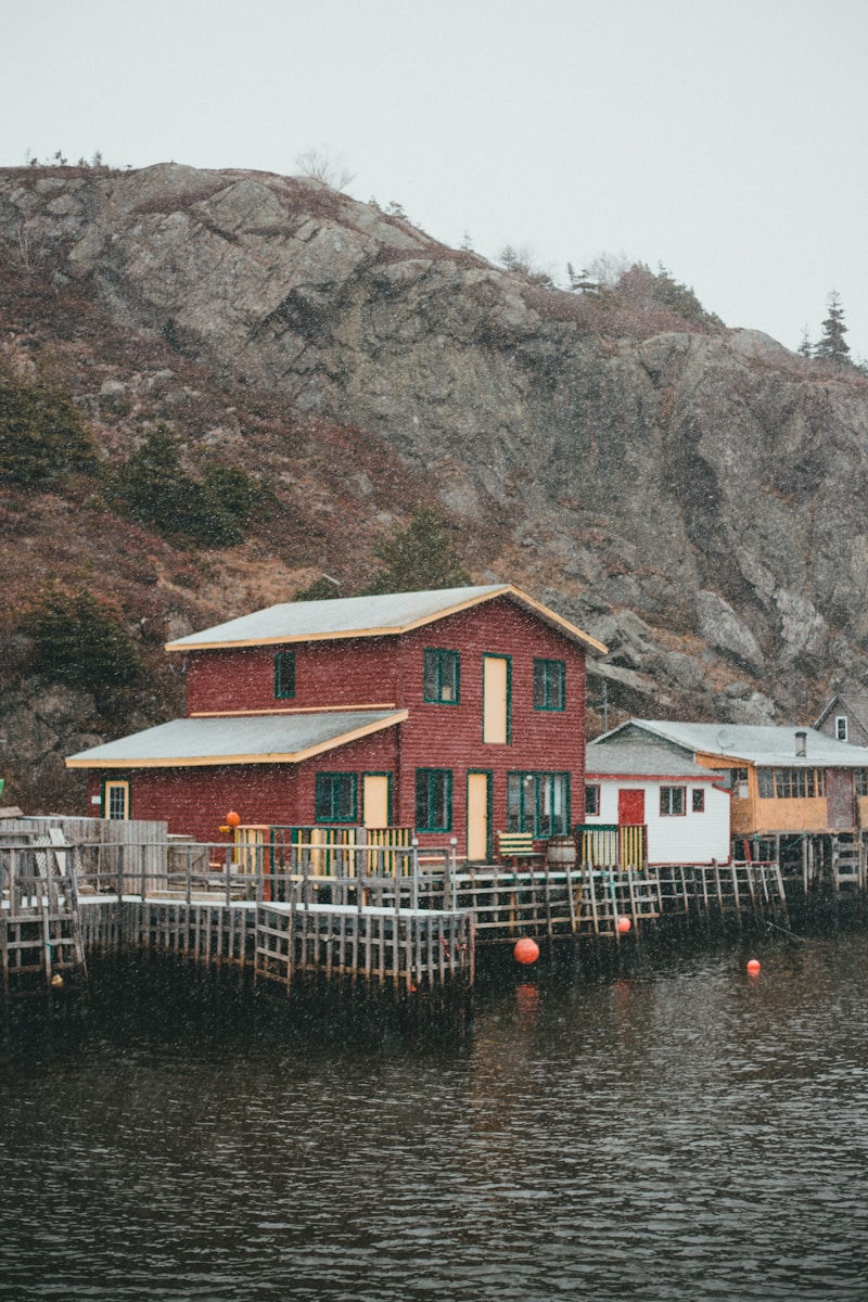 a red house sitting on top of a body of water